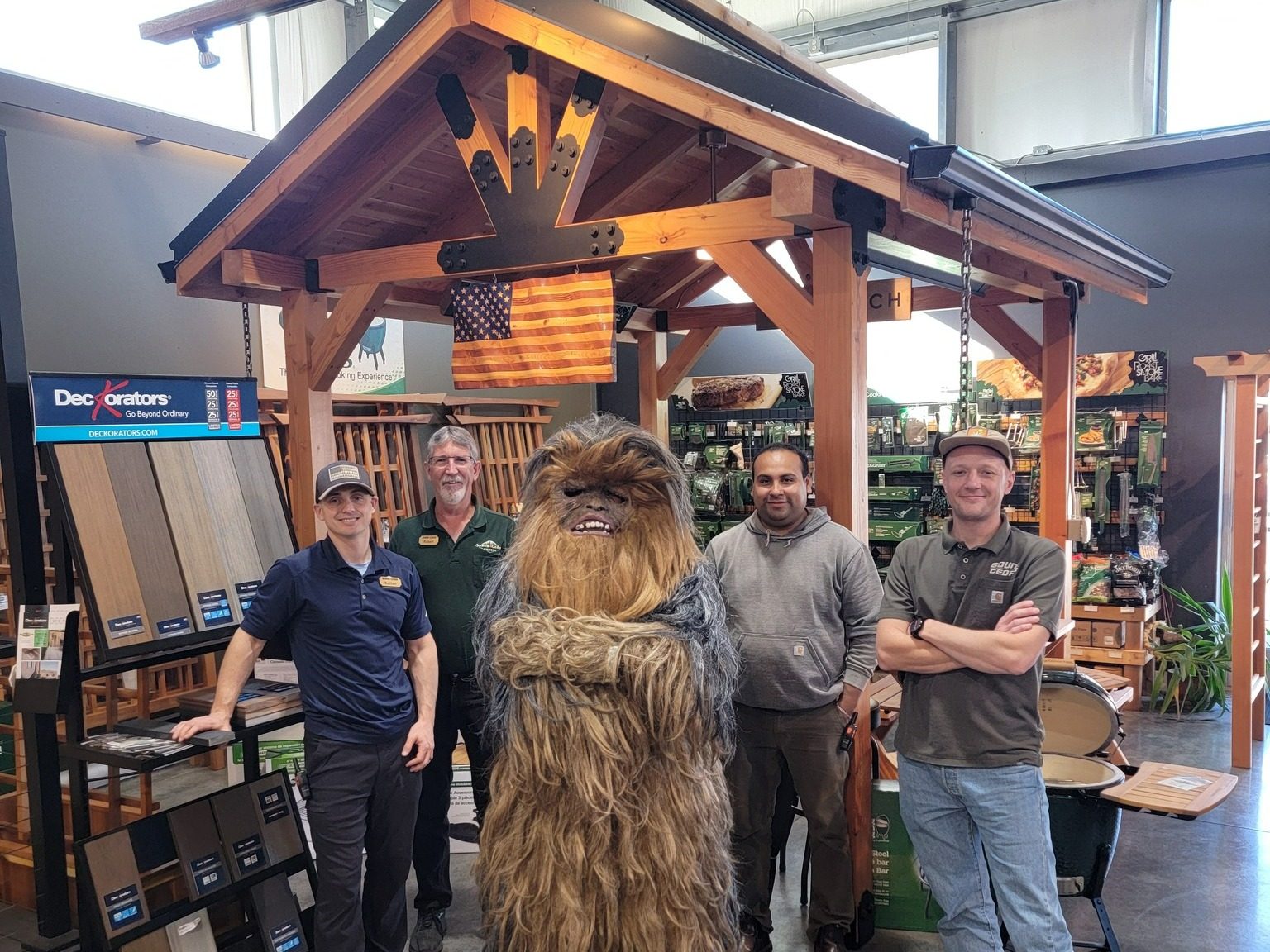 Photo of Sound Cedar Lumber employees posing with Big Foot from Skagit Big Foot Fest in their showroom.